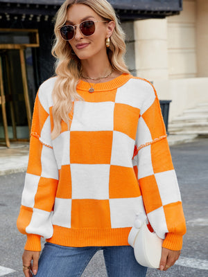 Checkerboard knit sweater in tangerine and white with balloon sleeves and crew neck.