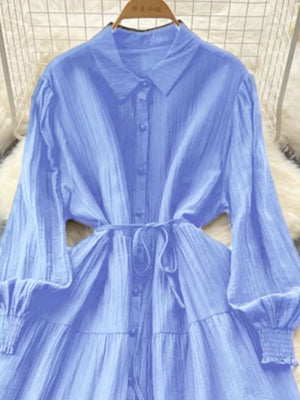 Blue textured tiered long sleeve midi dress with button-down front and tie waist.