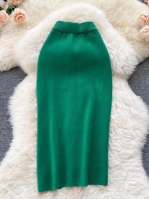 Green knit midi skirt with a ribbed waistband and a subtle side split.