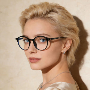Black acetate round frame eyeglasses with clear lenses on a woman.