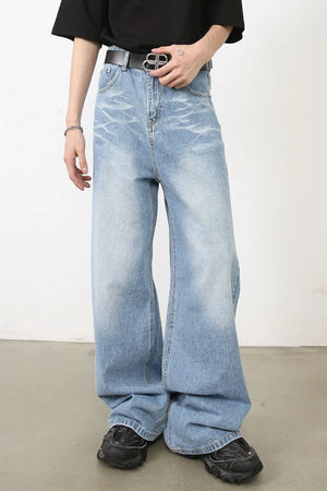 Oversized medium wash denim jeans with distressed details and a wide leg