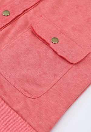Washed cotton utility jacket in burnt coral with snap-button flap pockets and ribbed hem.