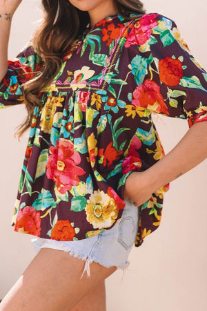 Embroidered floral babydoll blouse with yellow stitching detail and short sleeves.