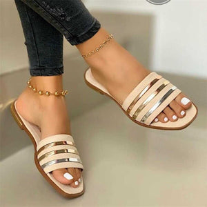 Beige open-toe flat sandals with metallic stripe detail.