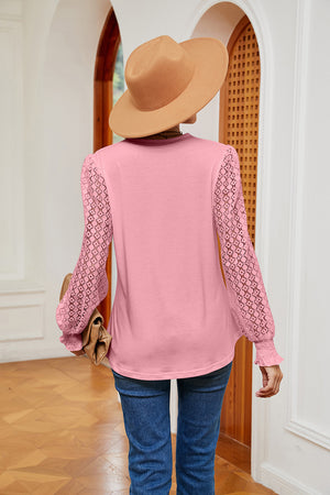 Pink knit v-neck blouse with lace sleeves and smocked cuffs.