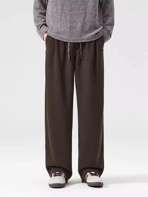 Men's brown loose-fit casual sweatpants with drawstring waist and pockets.