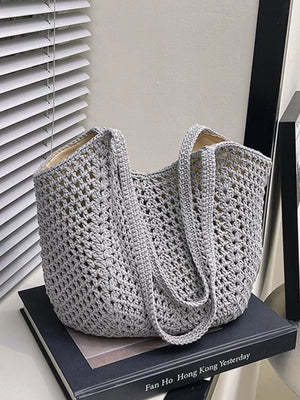 Grey woven straw shoulder bag with crochet detail and braided straps.
