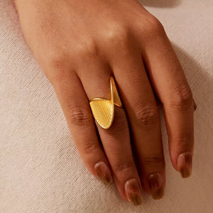 18k gold-plated ring with twisted texture and ribbed detail on a woman's hand.
