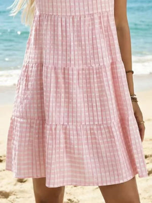 Pink tiered mini dress with a subtle checkered texture and a ruffled hem.