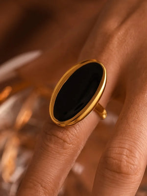 Gold cocktail ring with oval black onyx stone.