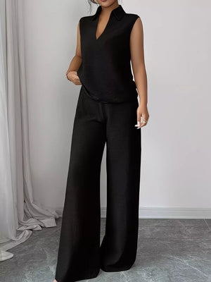 Black sleeveless collared V-neck top with textured fabric and matching wide-leg pants.