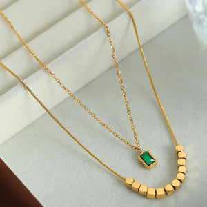 Gold layered necklace with emerald cube and cube beads