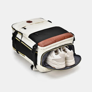 Beige travel backpack with black and brown contrast panels, showing shoe compartment with white sneakers.