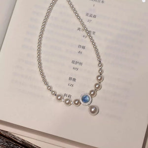 Luminous pearl choker with blue stone pendant and 925 silver chain.