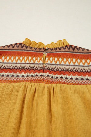 Mustard blouse with embroidered yoke and ruffled neckline detail.