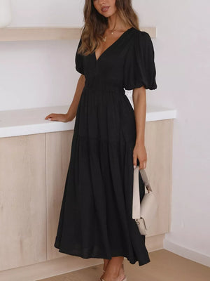 Black midi dress with puff sleeves, V-neck, and tiered skirt.