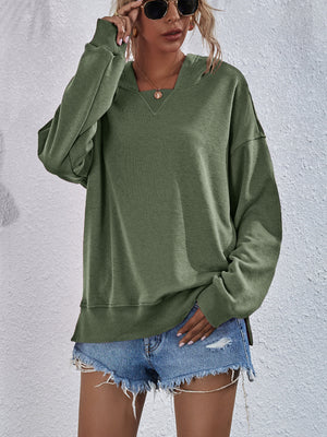 Moss green boxy hooded sweatshirt with split hem and v-neck detail.