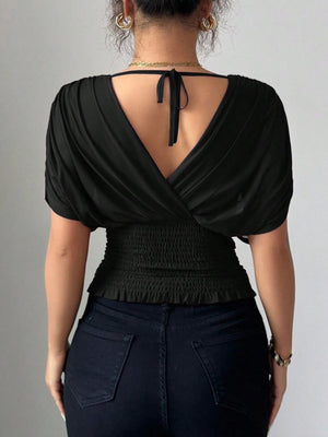 Black ruched surplice tunic with dolman sleeves and smocked waist detail.
