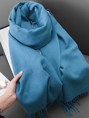 Light blue scarf with fringe detail and textured weave, styled for versatile wear.