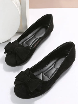 Black suede pointed-toe flats with bow embellishment and padded insole.