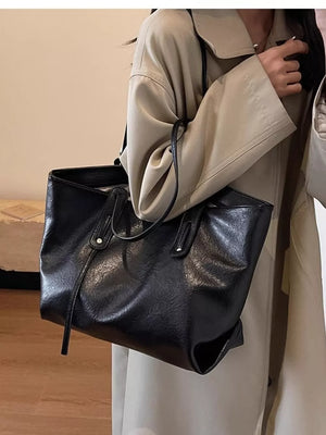 Black pu leather shoulder bag with slouchy design and double straps.