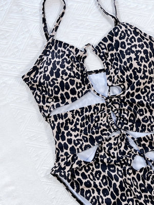 Leopard print one-piece swimsuit with cutout details and lace-up front.