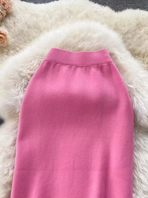 Pink knit midi skirt with ribbed waistband and side split detail.