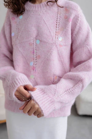 Blush pink diamond knit sweater with scattered iridescent sequins and open knit details.