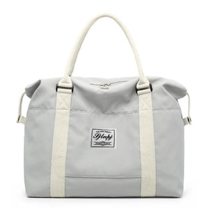 Light Gray large capacity travel duffel bag with cream straps and a front logo patch.