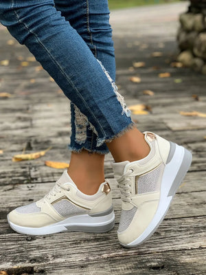 Beige platform sneakers with gemstone panels and gold accents.