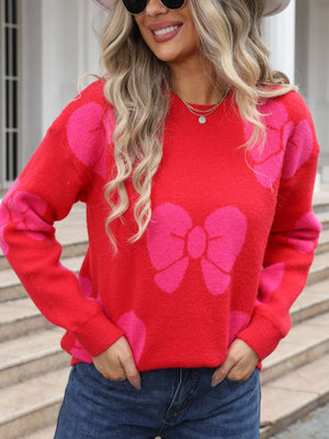Red acrylic sweater with pink bow pattern, crew neck, long sleeves.