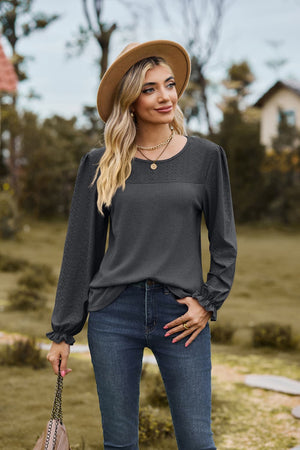 Dark gray waffle knit blouse with perforated detail and ruffled cuffs.