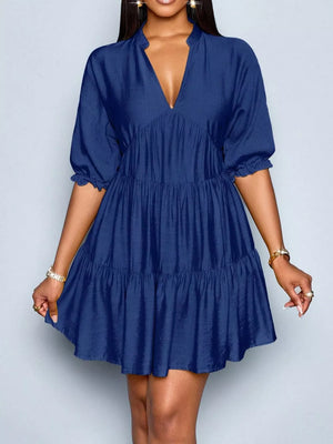 Navy blue tiered dress with notched V-neck and ruffled short sleeves.