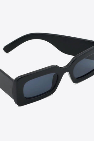 Black acetate rectangle sunglasses with dark lenses and thick frames.