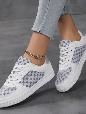 White canvas court sneakers with patterned panels and lace-up closure.