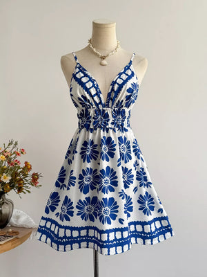 Floral V-neck mini dress with smocked waist and blue floral print on white.