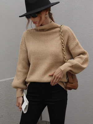 Tan ribbed knit turtleneck sweater with voluminous balloon sleeves.