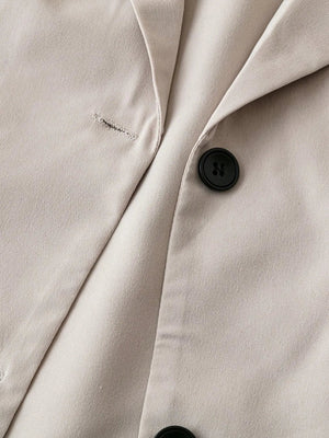 Light khaki short-sleeve blazer with black button detail and notched lapel.