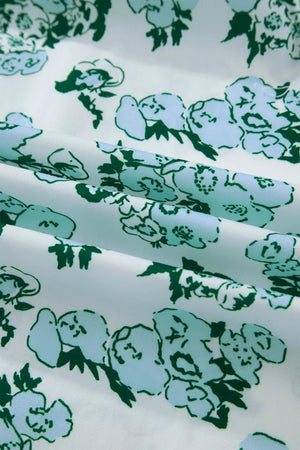 Polyester blouse with a white background and a green and light blue floral print.