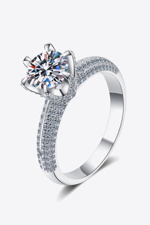 Silver pavé halo moissanite solitaire ring with a round cut center stone.