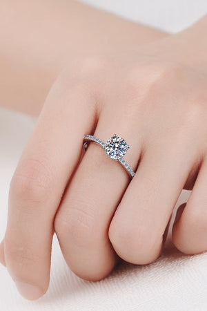 Sparkling moissanite ring in silver with a round cut center stone and pave band.