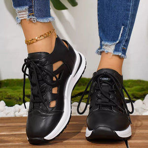 Chic black round toe lace-up sneakers with cut-out details and white soles.