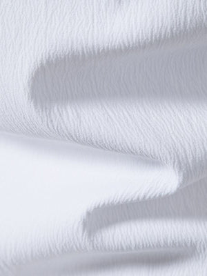 White cotton short sleeve shirt with textured fabric and band collar detail.