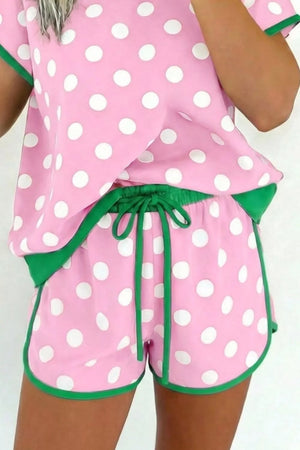 Polka dot pink pajama set with green trim and drawstring shorts.