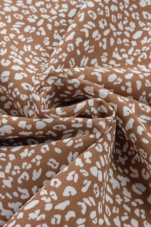 Brown sleeveless blouse with white leopard print and ruffled neckline detail.