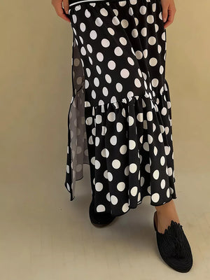 Black polka dot maxi skirt with a high slit and ruffled hem.