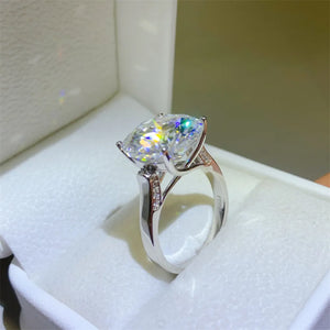 Radiant moissanite solitaire ring in silver with pave diamond band.