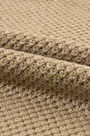Khaki textured knit turtleneck sweater with cap sleeves and a waffle knit pattern.