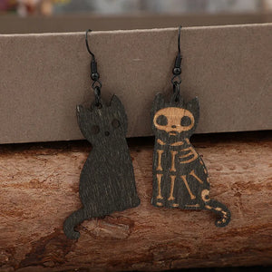 Black laser-cut cat earrings, one with skeleton detail, made of wood.