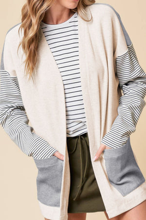 Colorblock stripe sleeve cardigan in light gray and cream with pockets.